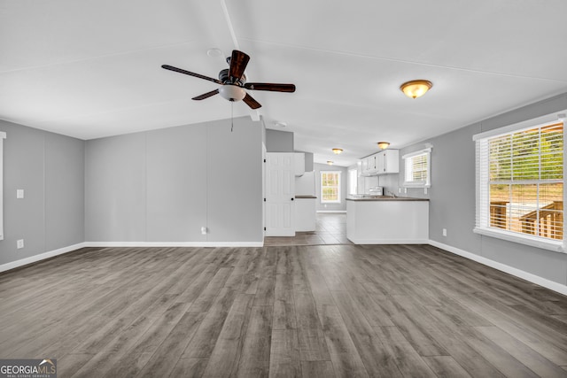 unfurnished living room with lofted ceiling, ceiling fan, and light hardwood / wood-style flooring