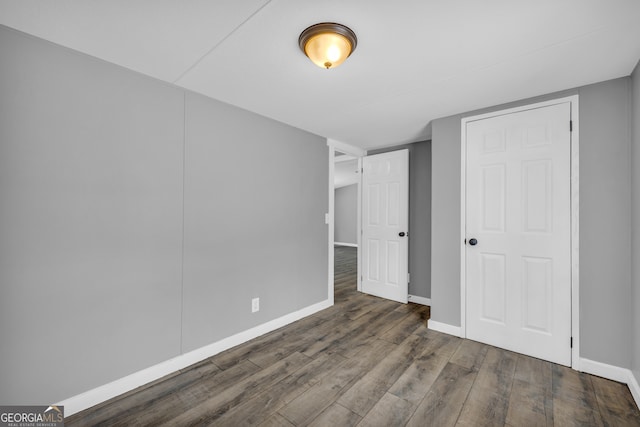 unfurnished bedroom with dark hardwood / wood-style flooring