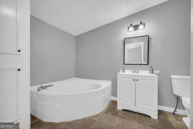 bathroom with a bathtub, tile patterned floors, vanity, and toilet