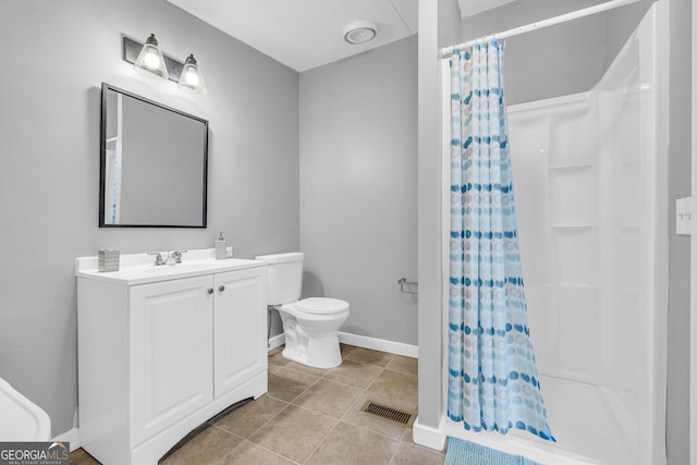 bathroom with tile patterned floors, toilet, vanity, and curtained shower