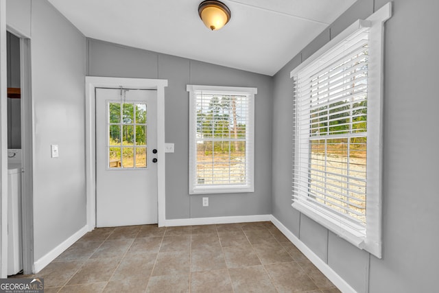 doorway featuring lofted ceiling and light tile patterned floors