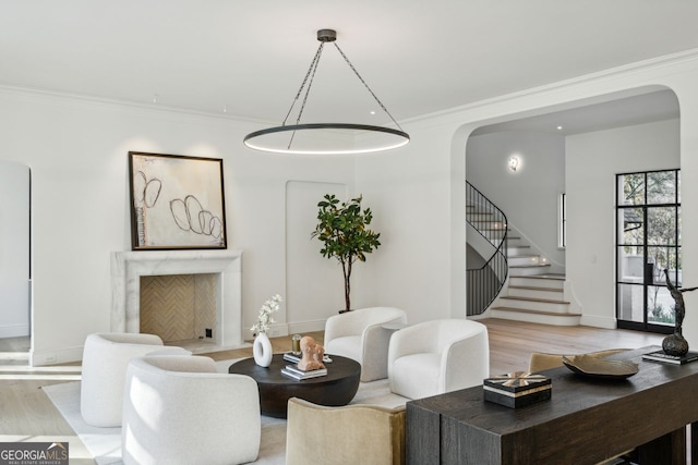 living room featuring light hardwood / wood-style floors, crown molding, and a premium fireplace