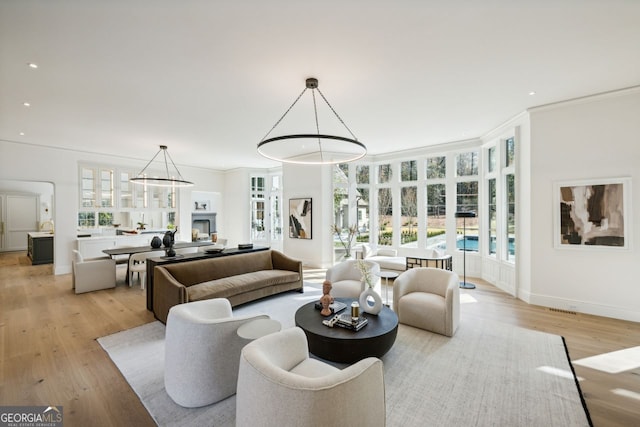 living room featuring light hardwood / wood-style flooring and ornamental molding