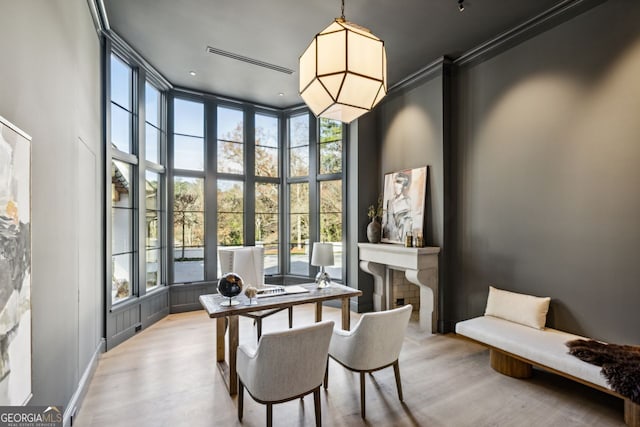 dining area with a towering ceiling, a healthy amount of sunlight, and light wood-type flooring