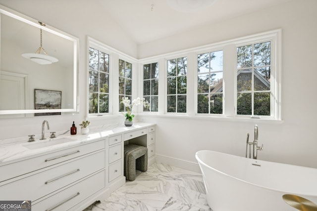 bathroom with vanity, a bathtub, vaulted ceiling, and plenty of natural light