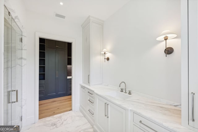 bathroom with vanity, a shower with shower door, and wood-type flooring