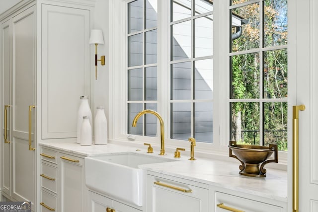 interior space featuring light stone counters and sink