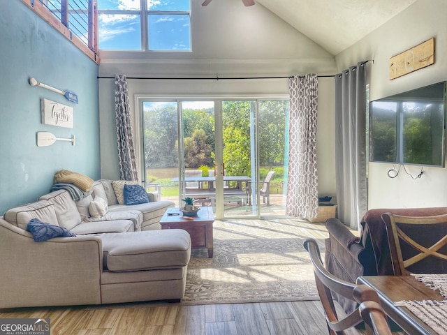 living room with hardwood / wood-style flooring, high vaulted ceiling, and ceiling fan