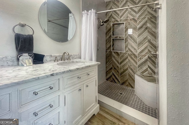 bathroom with vanity, wood-type flooring, and walk in shower