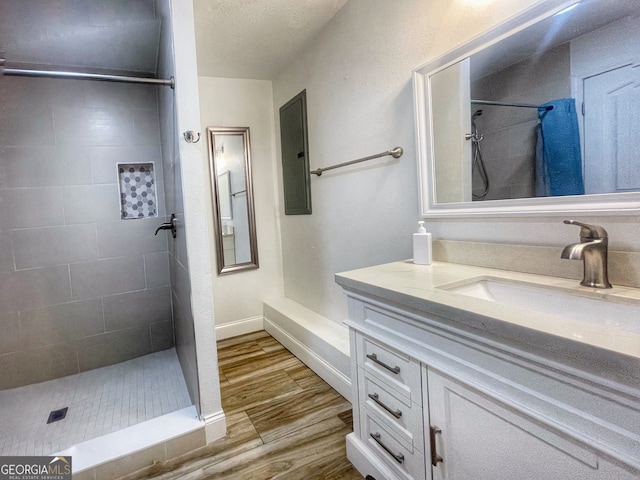 bathroom with vanity, hardwood / wood-style flooring, and tiled shower