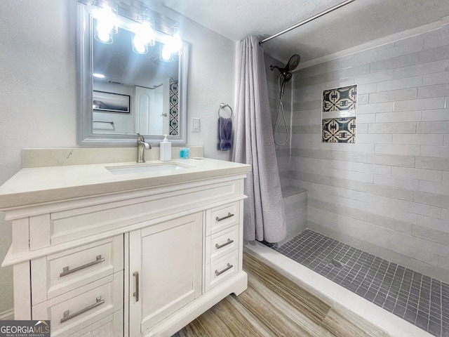 bathroom featuring vanity, walk in shower, and wood-type flooring