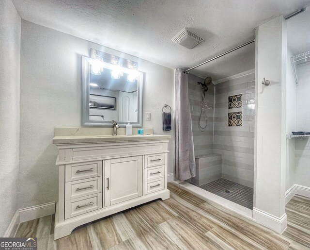 bathroom featuring vanity, hardwood / wood-style floors, a shower with curtain, and a textured ceiling