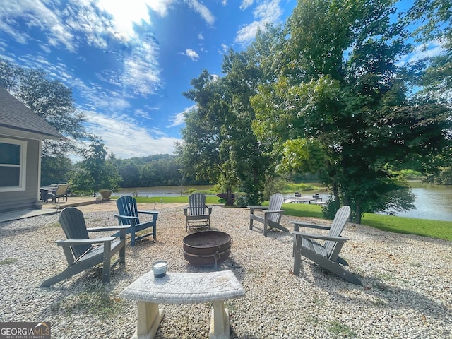 view of patio with a water view and an outdoor fire pit