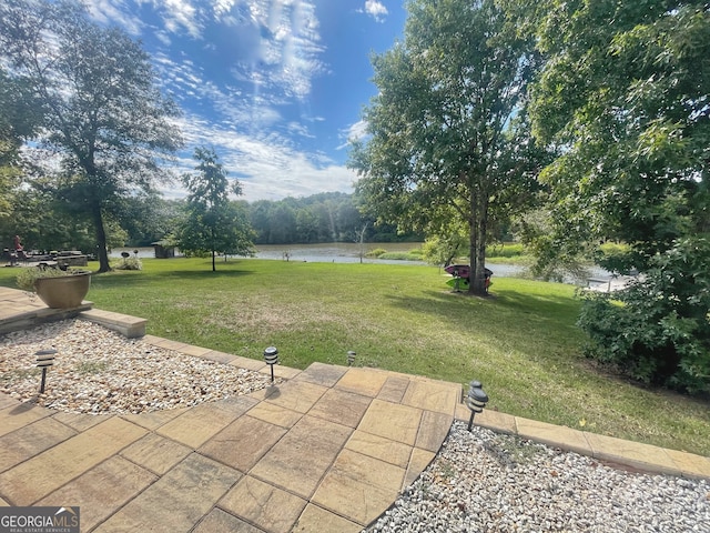 view of yard featuring a patio area and a water view