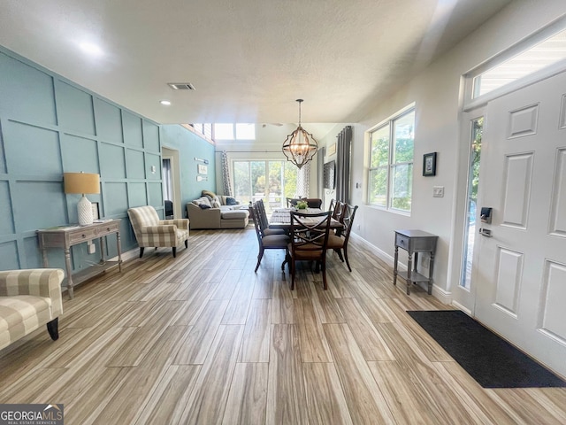 dining area featuring light hardwood / wood-style floors and an inviting chandelier