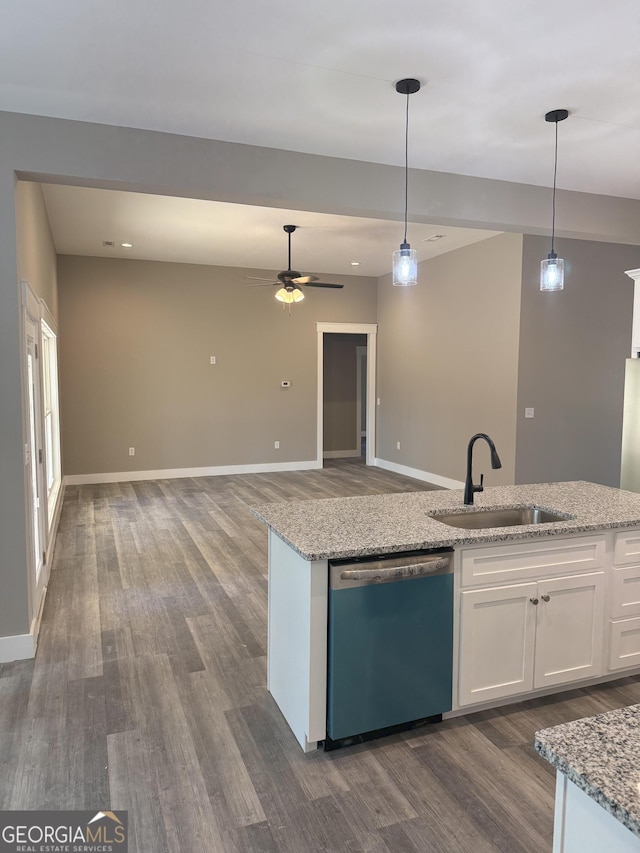 kitchen featuring white cabinetry, sink, hanging light fixtures, stainless steel dishwasher, and light stone counters