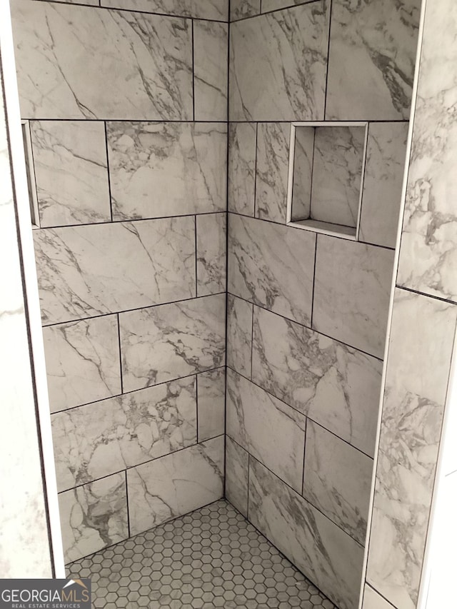 interior details featuring tiled shower