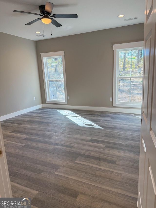 spare room with dark wood-type flooring and ceiling fan