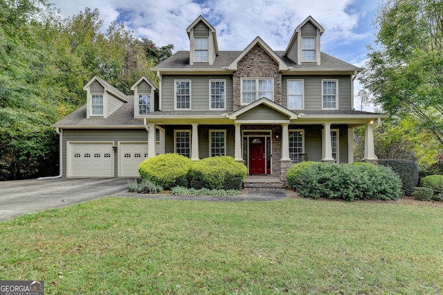 view of front of property featuring a front yard, a garage, and a porch