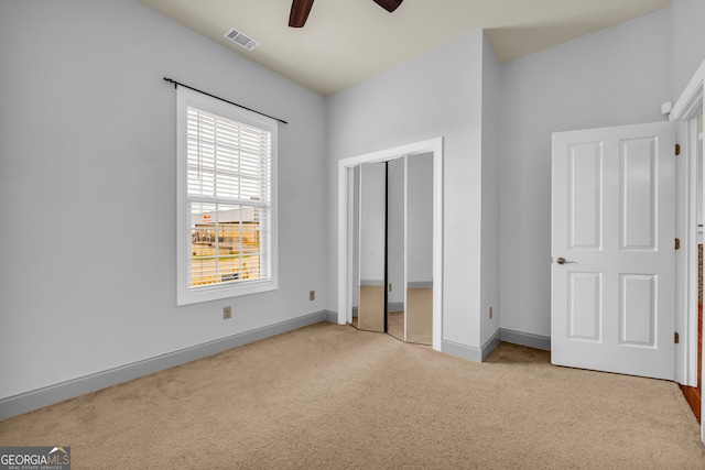 unfurnished bedroom featuring light carpet and ceiling fan