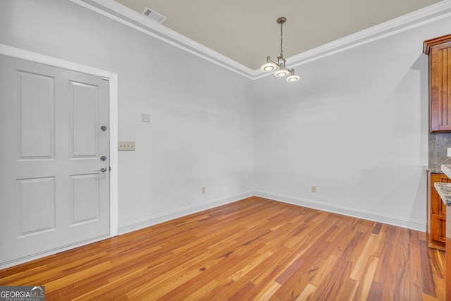 unfurnished dining area with ornamental molding and light hardwood / wood-style flooring