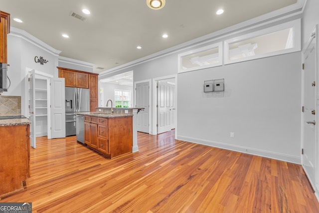 kitchen with light wood-type flooring, decorative backsplash, ornamental molding, a center island with sink, and stainless steel refrigerator with ice dispenser