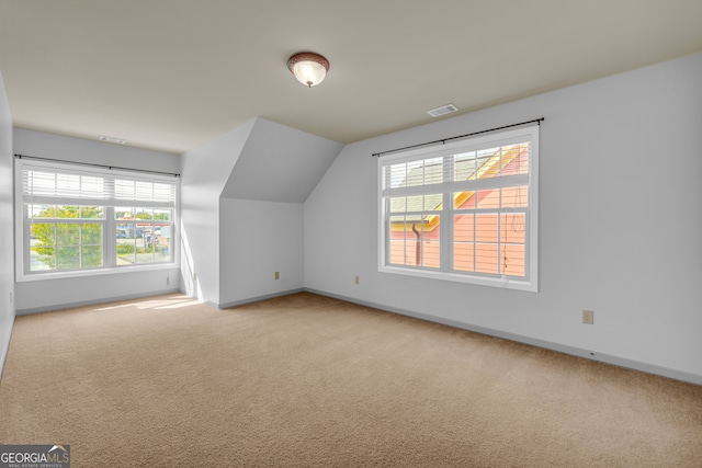 bonus room featuring vaulted ceiling and light colored carpet