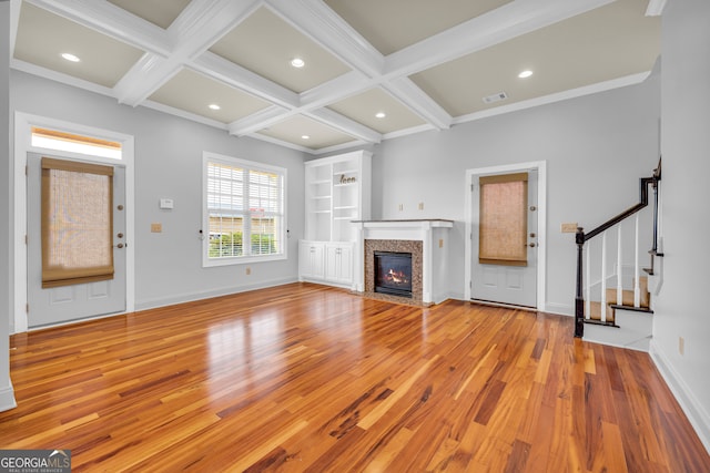 unfurnished living room with ornamental molding, beamed ceiling, coffered ceiling, and light hardwood / wood-style floors