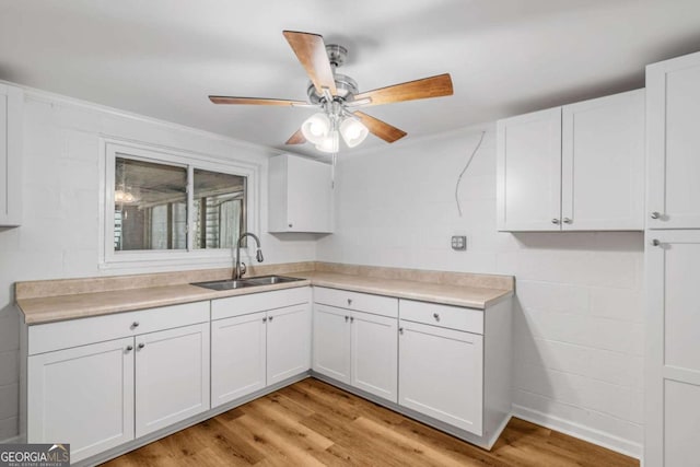 kitchen featuring ceiling fan, white cabinetry, sink, and light hardwood / wood-style floors