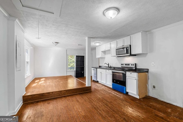 kitchen with a textured ceiling, appliances with stainless steel finishes, dark hardwood / wood-style floors, and white cabinetry