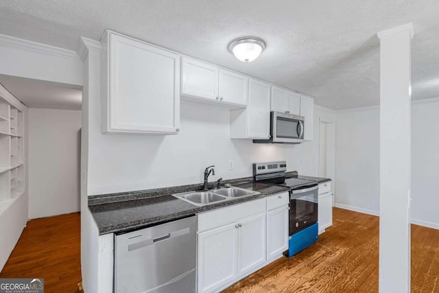 kitchen with sink, stainless steel appliances, hardwood / wood-style floors, and white cabinetry