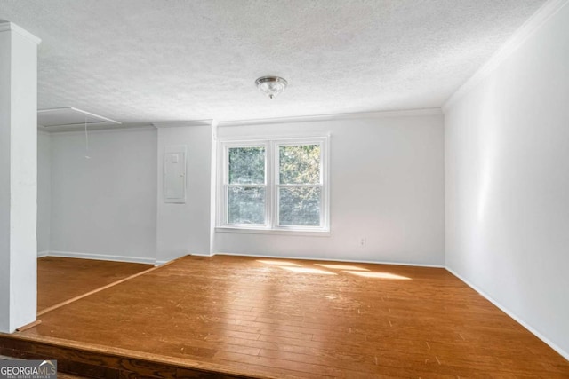 spare room featuring hardwood / wood-style floors and a textured ceiling