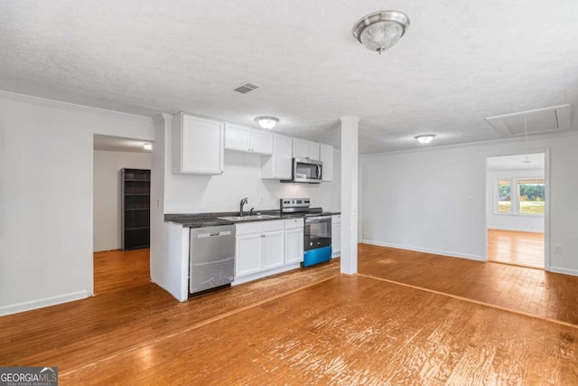 kitchen featuring appliances with stainless steel finishes, hardwood / wood-style floors, sink, and white cabinets