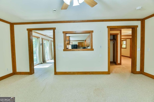 empty room featuring ceiling fan and light carpet