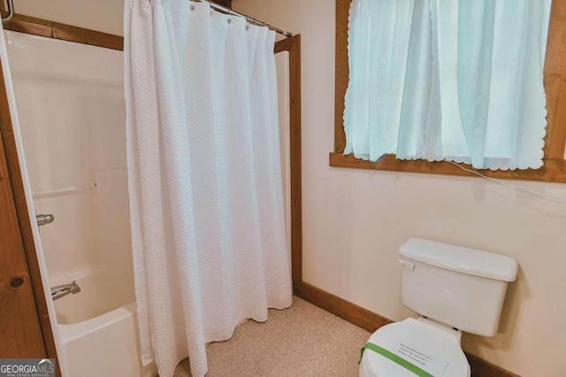 bathroom featuring shower / bath combo with shower curtain and toilet