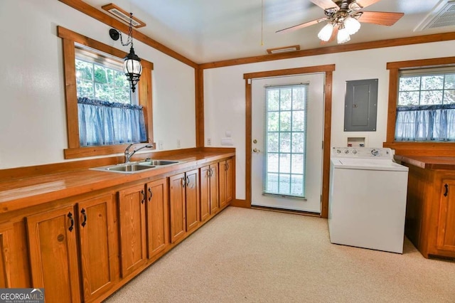 kitchen featuring electric panel, washer / dryer, plenty of natural light, and decorative light fixtures