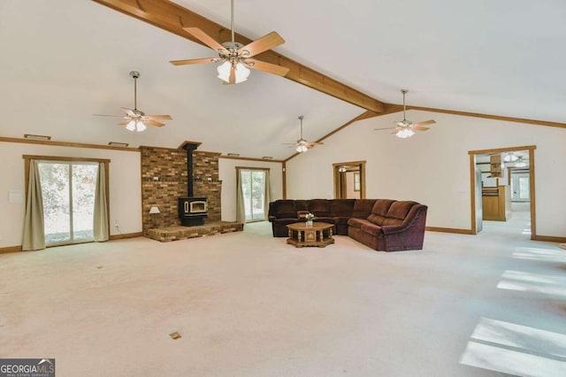 carpeted living room with a wood stove, high vaulted ceiling, beamed ceiling, and plenty of natural light