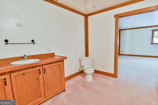 bathroom featuring ornamental molding, vanity, and toilet