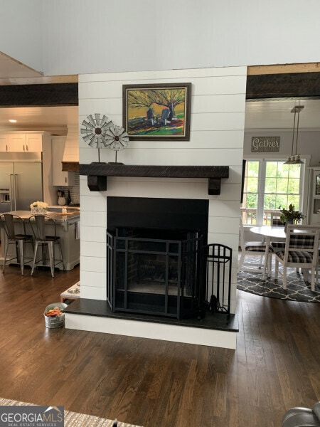 interior details with hardwood / wood-style flooring, stainless steel built in fridge, and wood walls