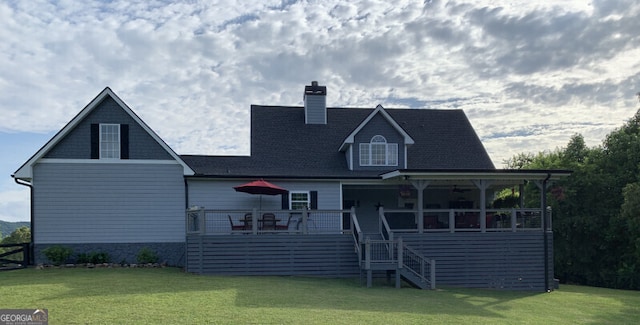 rear view of house featuring a yard and a deck