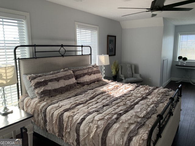 bedroom with ceiling fan, dark hardwood / wood-style flooring, and multiple windows