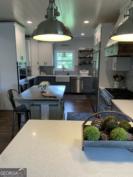 kitchen featuring dark hardwood / wood-style flooring, sink, decorative backsplash, white cabinets, and appliances with stainless steel finishes