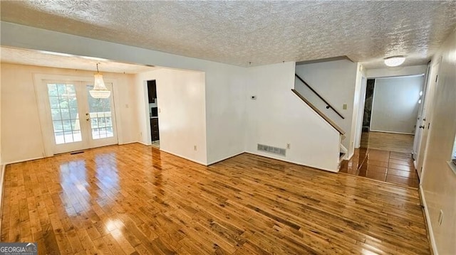 interior space featuring french doors, a textured ceiling, and wood-type flooring