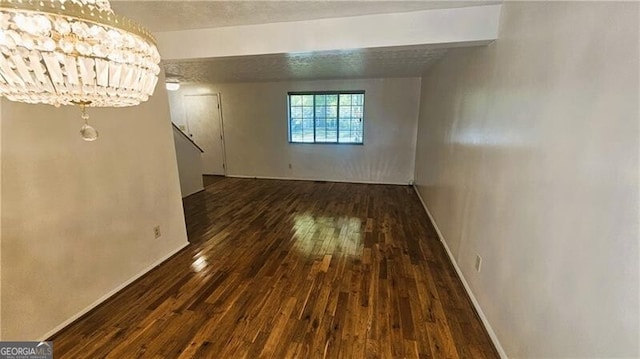 interior space featuring beam ceiling, an inviting chandelier, and dark hardwood / wood-style floors