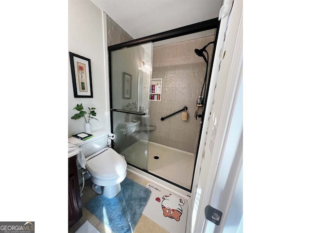 bathroom featuring an enclosed shower, vanity, and toilet