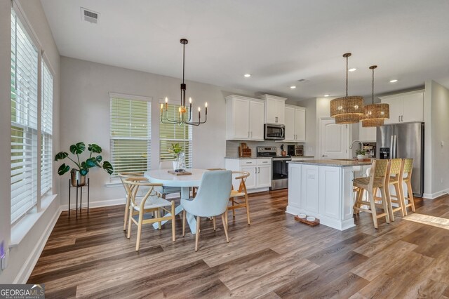 22 Allston Ln, Savannah, GA 31407 - kitchen featuring white cabinets, dark wood-style flooring, a notable chandelier, appliances with stainless steel finishes, and a kitchen island with sink