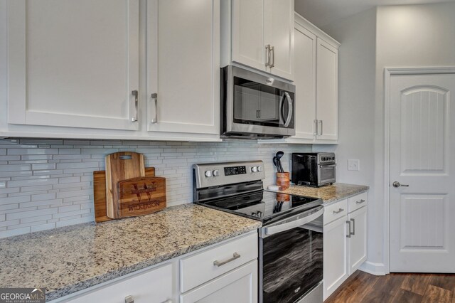 22 Allston Ln, Savannah, GA 31407 - kitchen featuring dark wood-type flooring, white cabinetry, light stone counters, backsplash, and stainless steel appliances