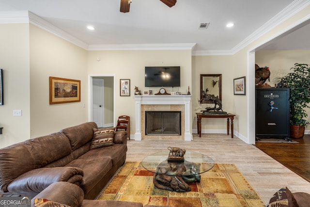 living room with a fireplace, crown molding, hardwood / wood-style flooring, and ceiling fan