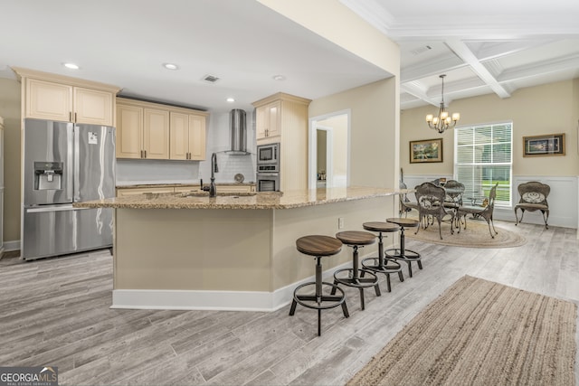 kitchen featuring beamed ceiling, light wood-type flooring, coffered ceiling, stainless steel appliances, and light stone countertops