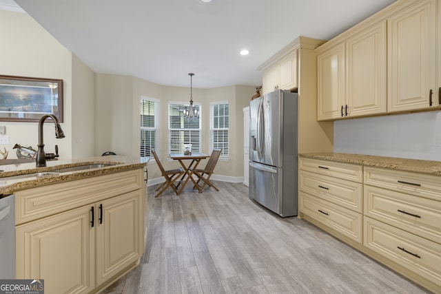 kitchen featuring sink, light hardwood / wood-style floors, stainless steel fridge with ice dispenser, decorative light fixtures, and cream cabinetry